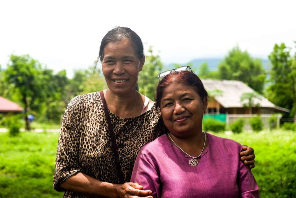 A woman from Nan and a woman from Mae Moh pose after connecting around their shared stories of facing pollution and threats to their local environments.