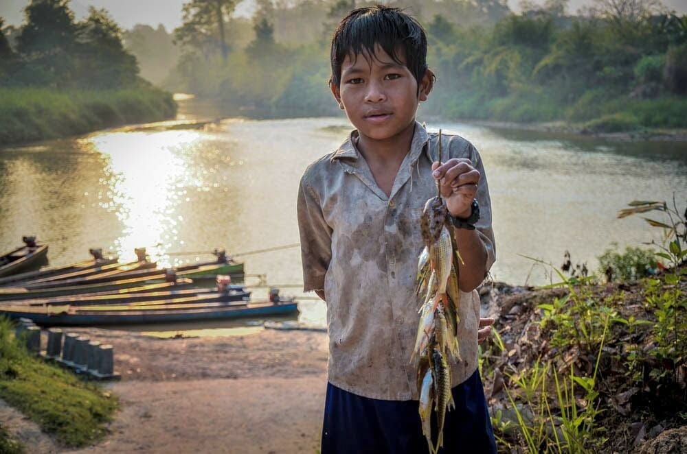 A young Mondul Yorn villagers shows the fish that he caught.
